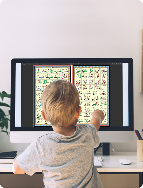 A child pointing at a computer screen displaying a colorful game